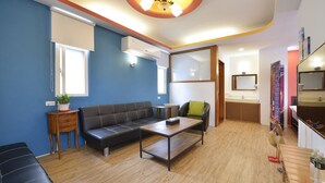 Una sala moderna con un sofá, una mesa de centro y una mesita auxiliar con una planta.