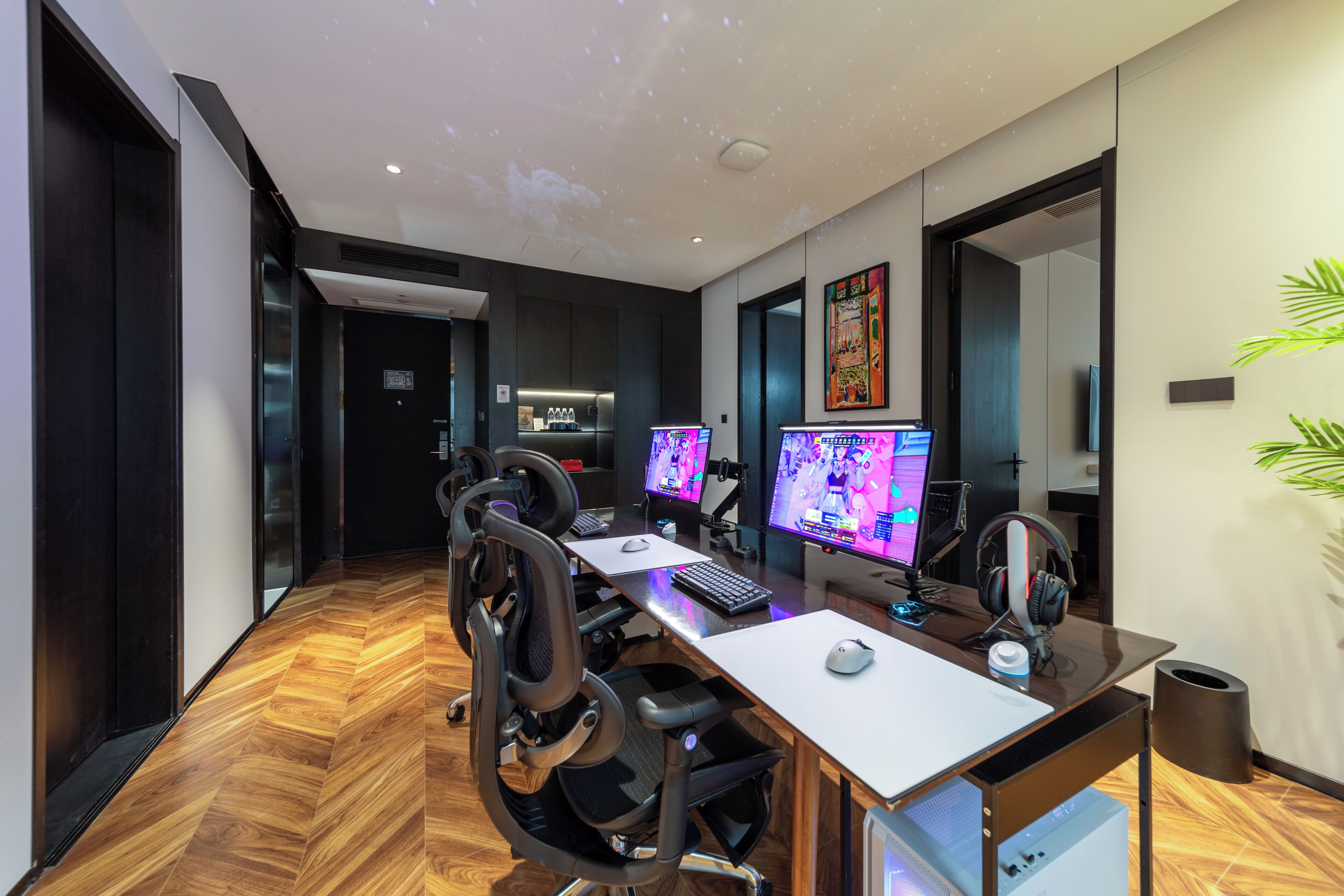 Un bureau moderne doté de plusieurs postes de travail, d’un espace cuisine et d’un grand miroir.