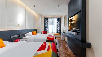 A hotel room with two beds, a TV, a desk, and a large window with curtains.