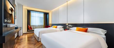 Habitación de hotel con dos camas, televisión, escritorio y ventana con cortinas.