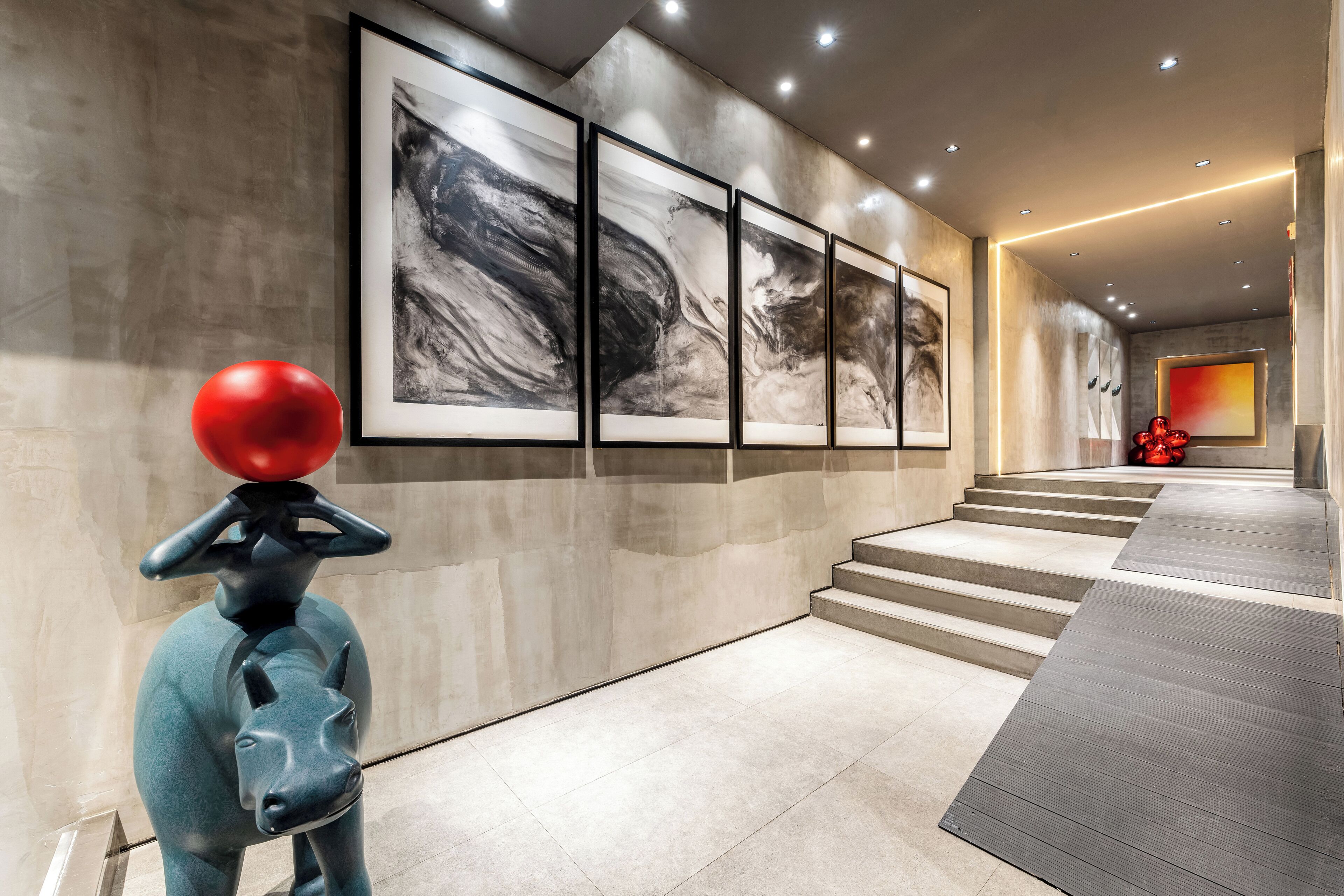 A modern interior with a staircase, abstract art, and a unique sculpture.