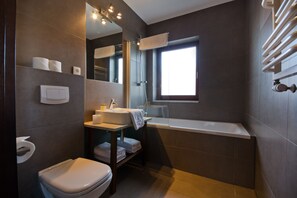 A modern bathroom with a toilet, sink, and bathtub. - Imperial Apartments - Martini (Sopot)