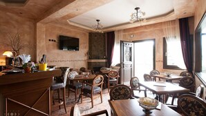Un restaurant avec des meubles en bois, un lustre et un téléviseur accroché au mur.