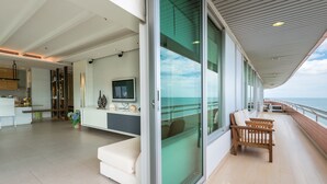 Um interior moderno com cozinha, área de estar e varanda com vista para o mar.