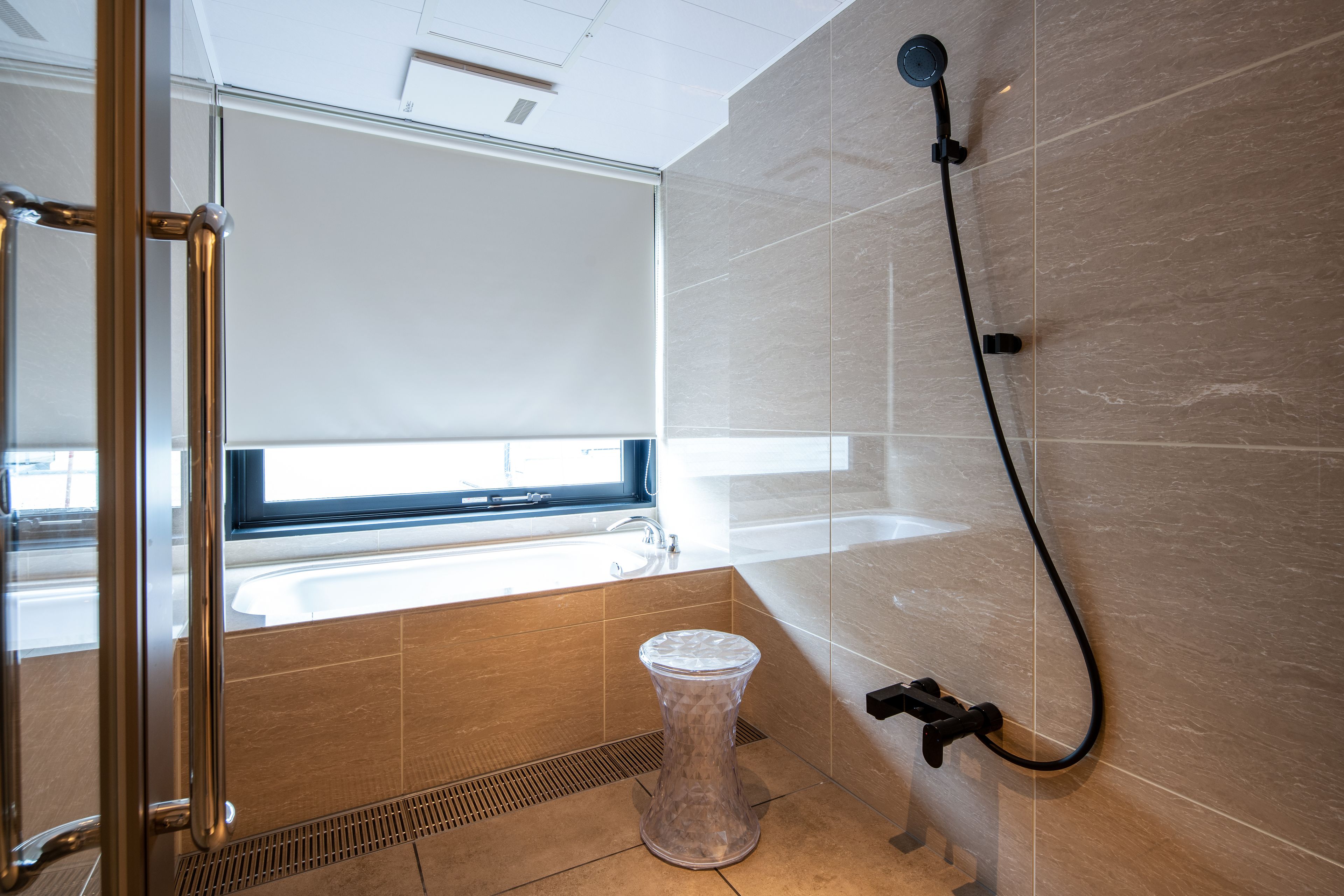 A modern bathroom with a glass shower enclosure, a bathtub, and a toilet.