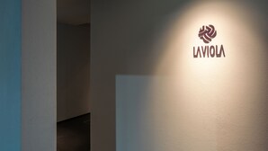 Un pasillo con un logotipo en la pared y una lámpara empotrada en el techo.