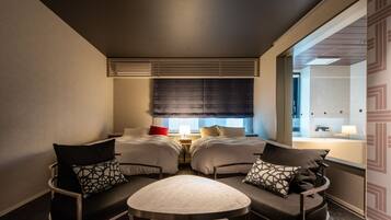 A hotel room with two beds, a small table, and two chairs.