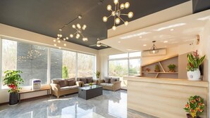 A spacious lobby with a modern design, featuring a reception desk, seating area with sofas, and large windows providing natural light. - Brother B&B (Magong)