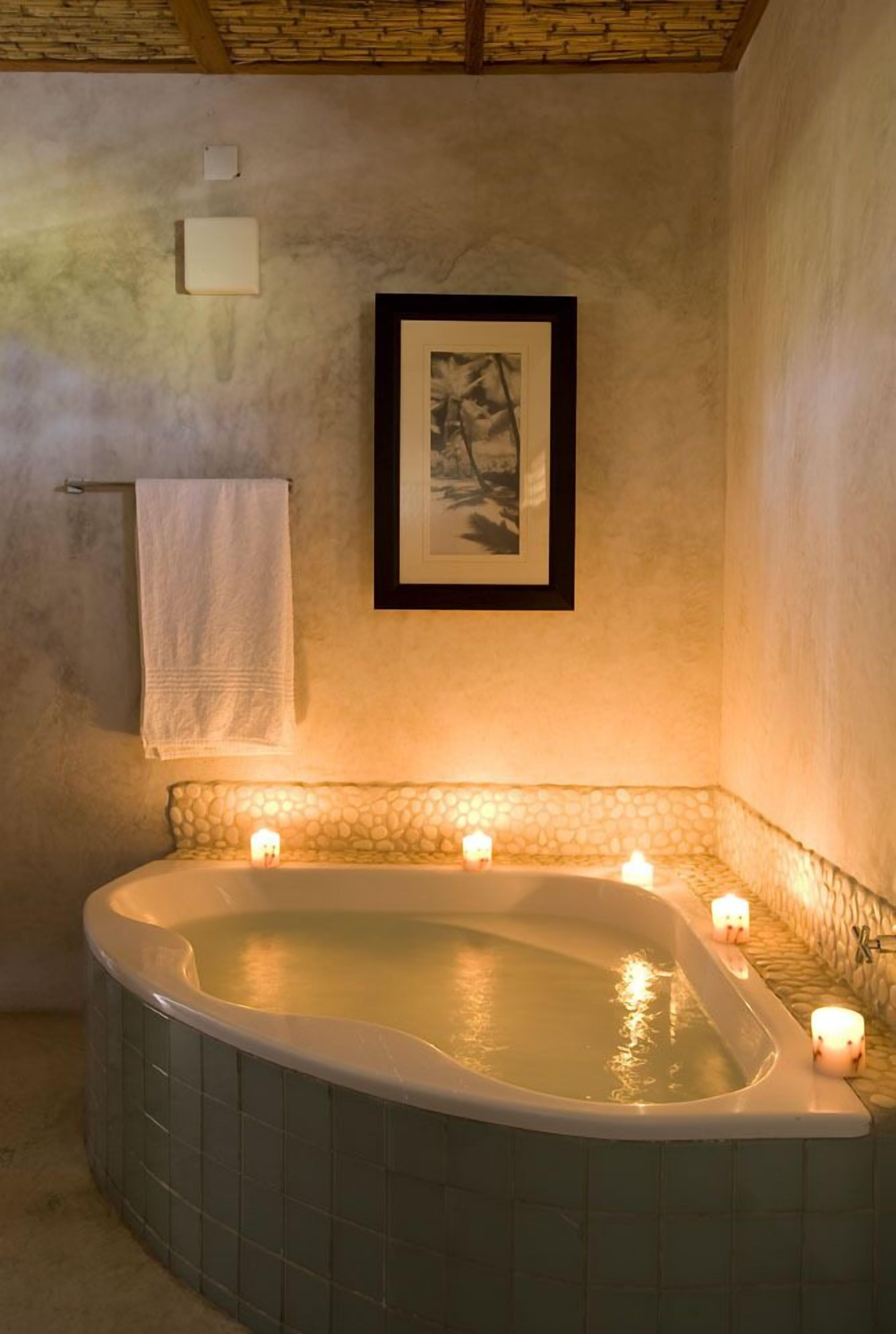 A bathroom with a freestanding bathtub, a framed picture on the wall, and a towel hanging on a rack.