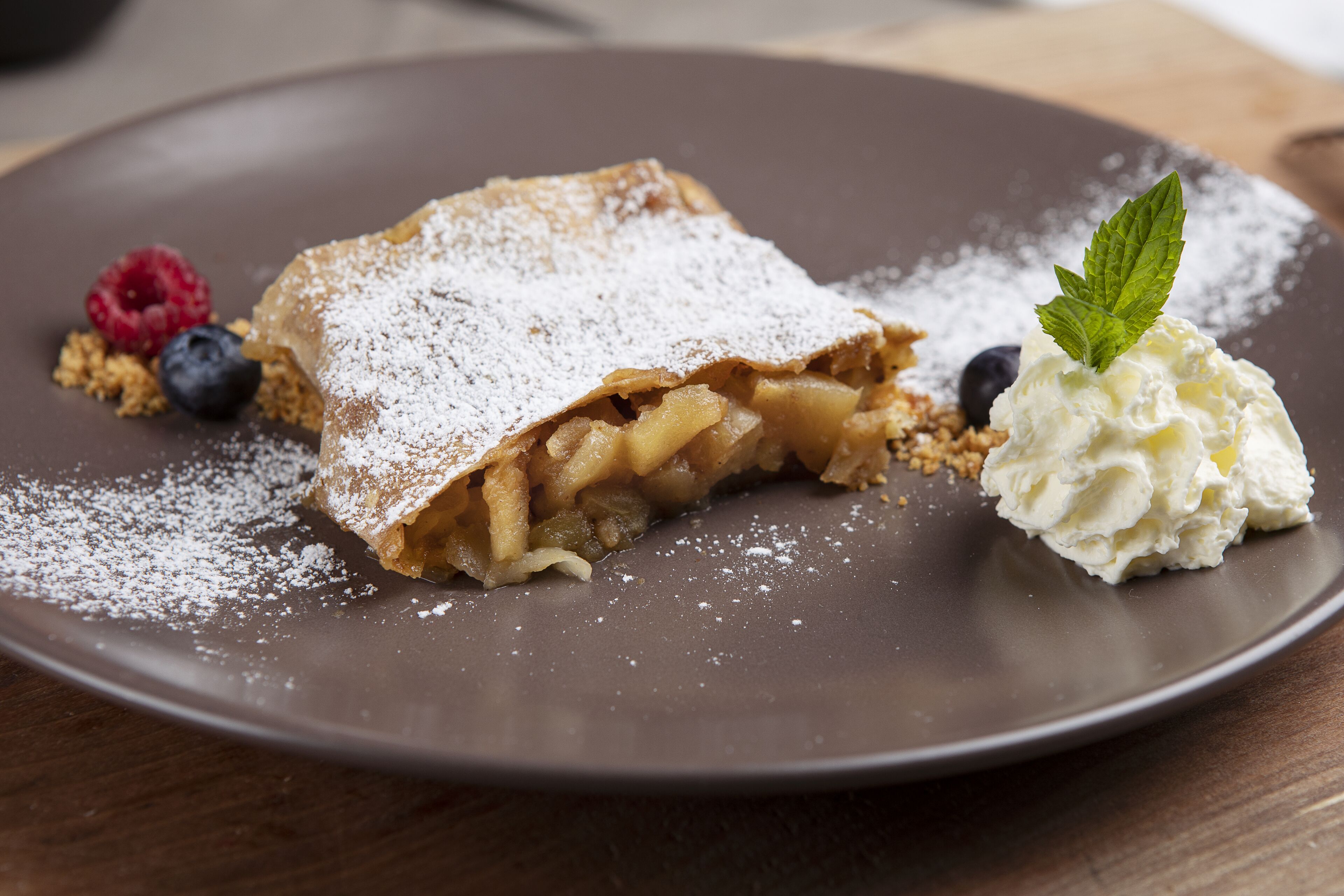 A dessert plate with a pastry, berries, and whipped cream.