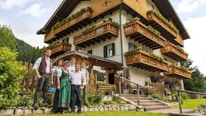 A traditional Alpine-style building with wooden balconies and flower boxes. - Rifugio Cereda (Primiero San Martino di Castrozza)