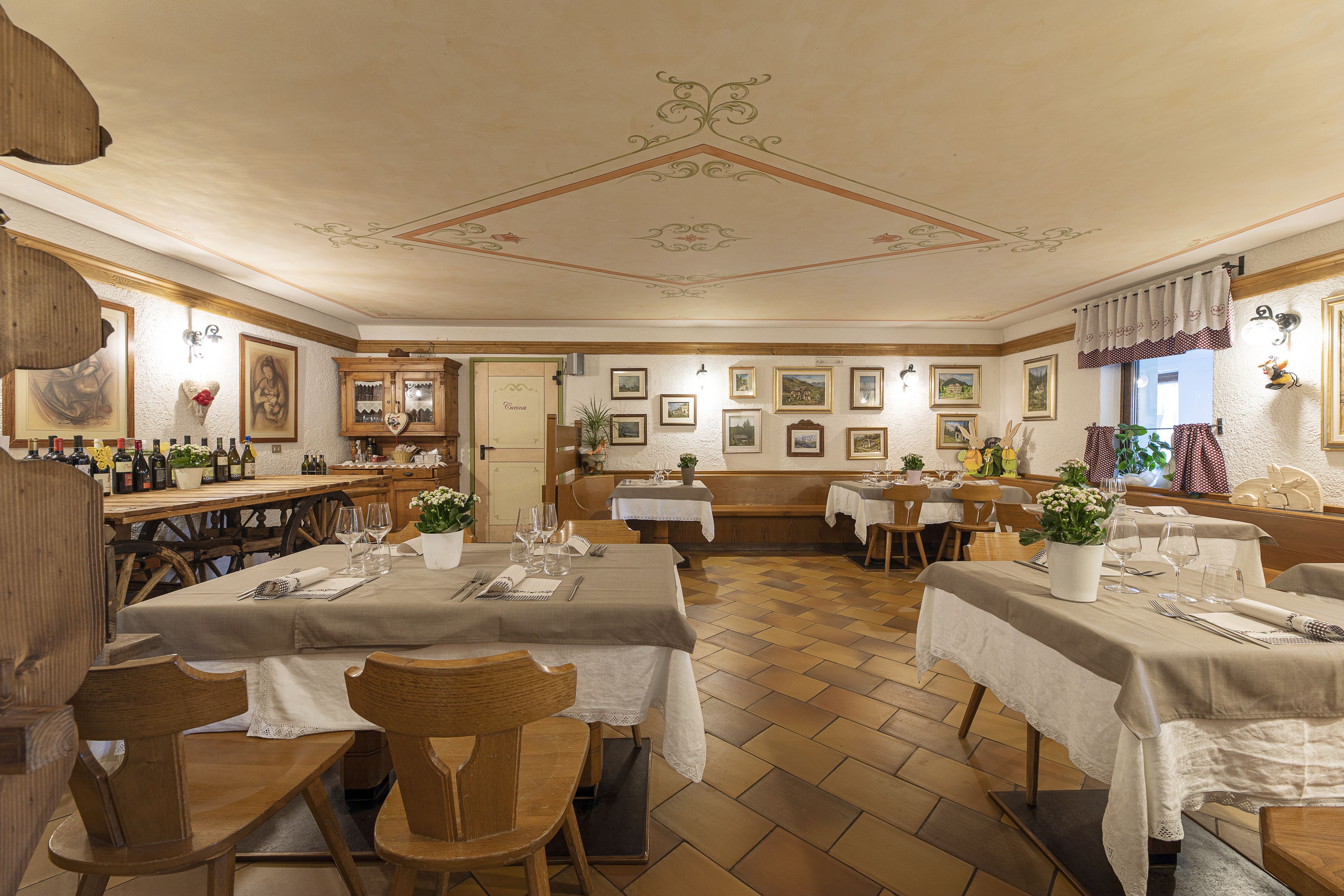 Un restaurante con varias mesas, sillas y una zona de bar.