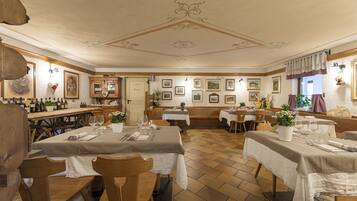 Un restaurante con varias mesas, sillas y una zona de bar.