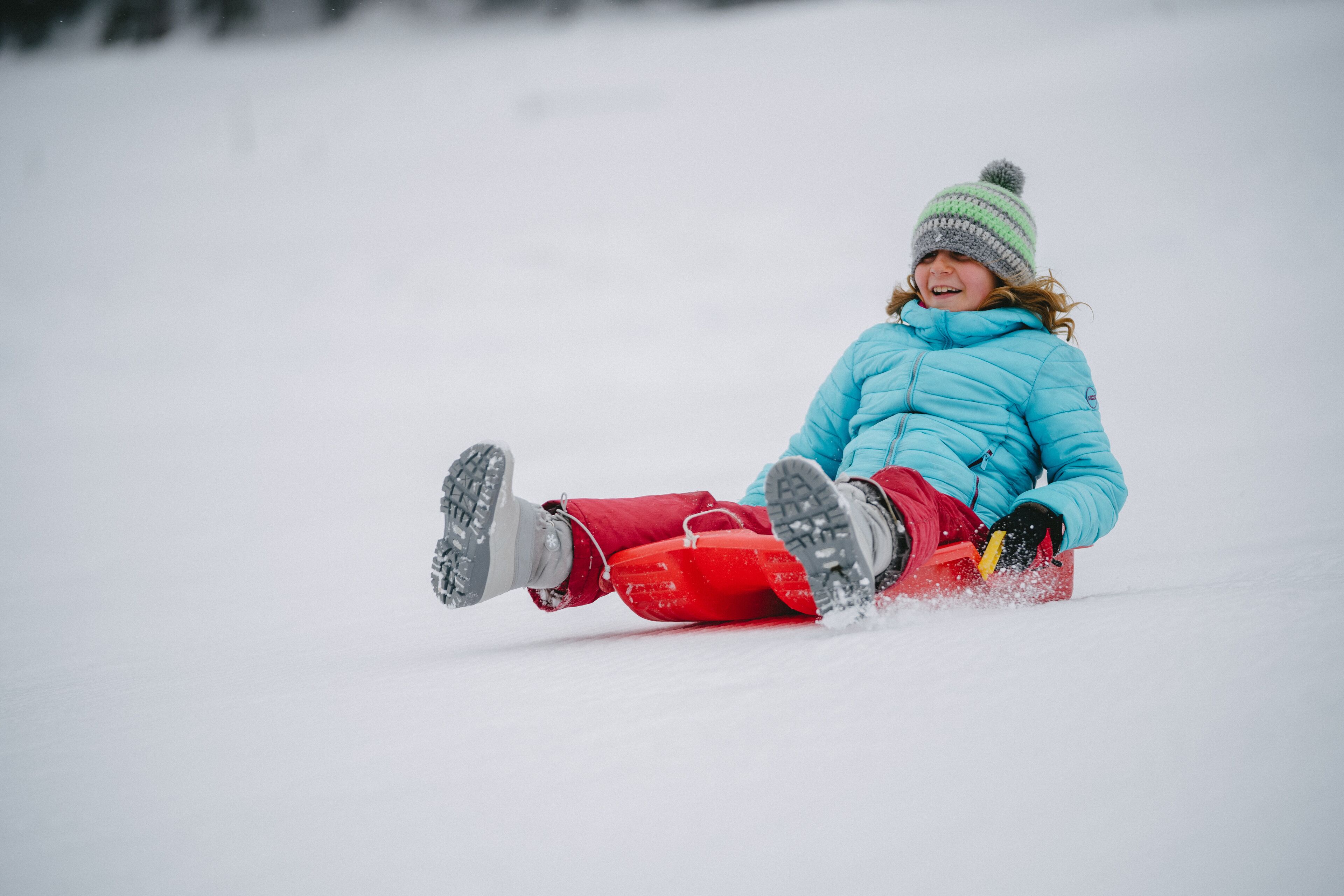 Eine Person rodel herunter eine schneebedeckte Hänge.