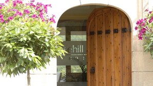 Een gebouwentree met een houten deur en een bord waarop 'Sehill HOT' staat.