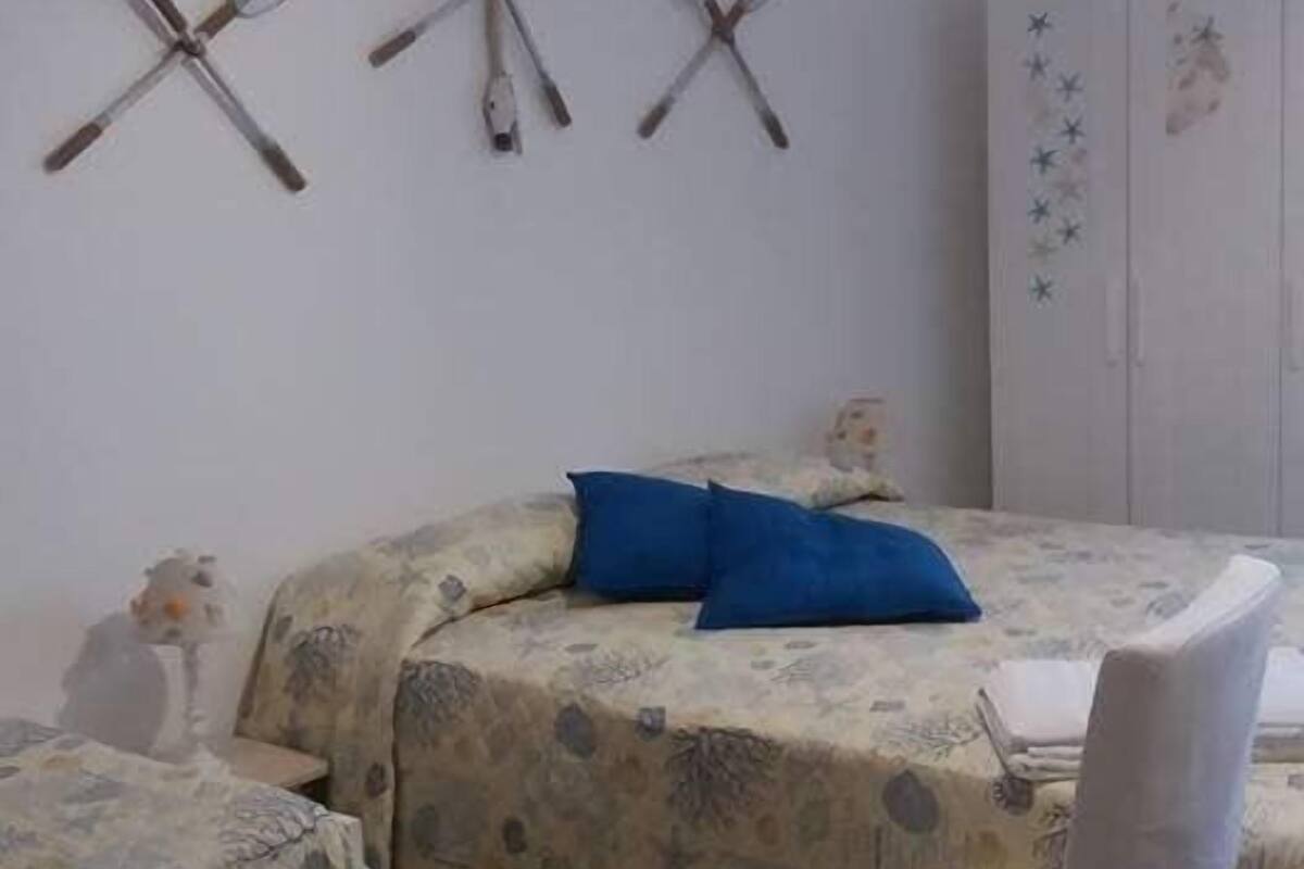 Un dormitorio con cama, una silla y un armario.
