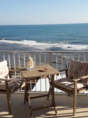 A terrace with a view of the sea, featuring a table and two chairs. - Casa Maritrì (Pachino)