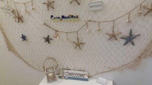 A wall decorated with starfish and a 'Welcome' sign, indicating a themed area or entrance. - Casa Maritrì (Pachino)