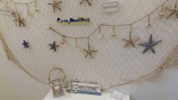 A wall decorated with starfish and a 'Welcome' sign, indicating a themed area or entrance.