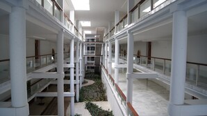 A multi-level atrium with glass railings, white columns, and a central garden area. - Parque Botanico Resort & Country Club (Benahavis)