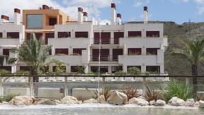 A modern building with multiple balconies and a water feature in front. - Parque Botanico Resort & Country Club (Benahavis)