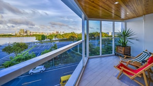 Un balcon donnant sur un paysage urbain et un parking.
