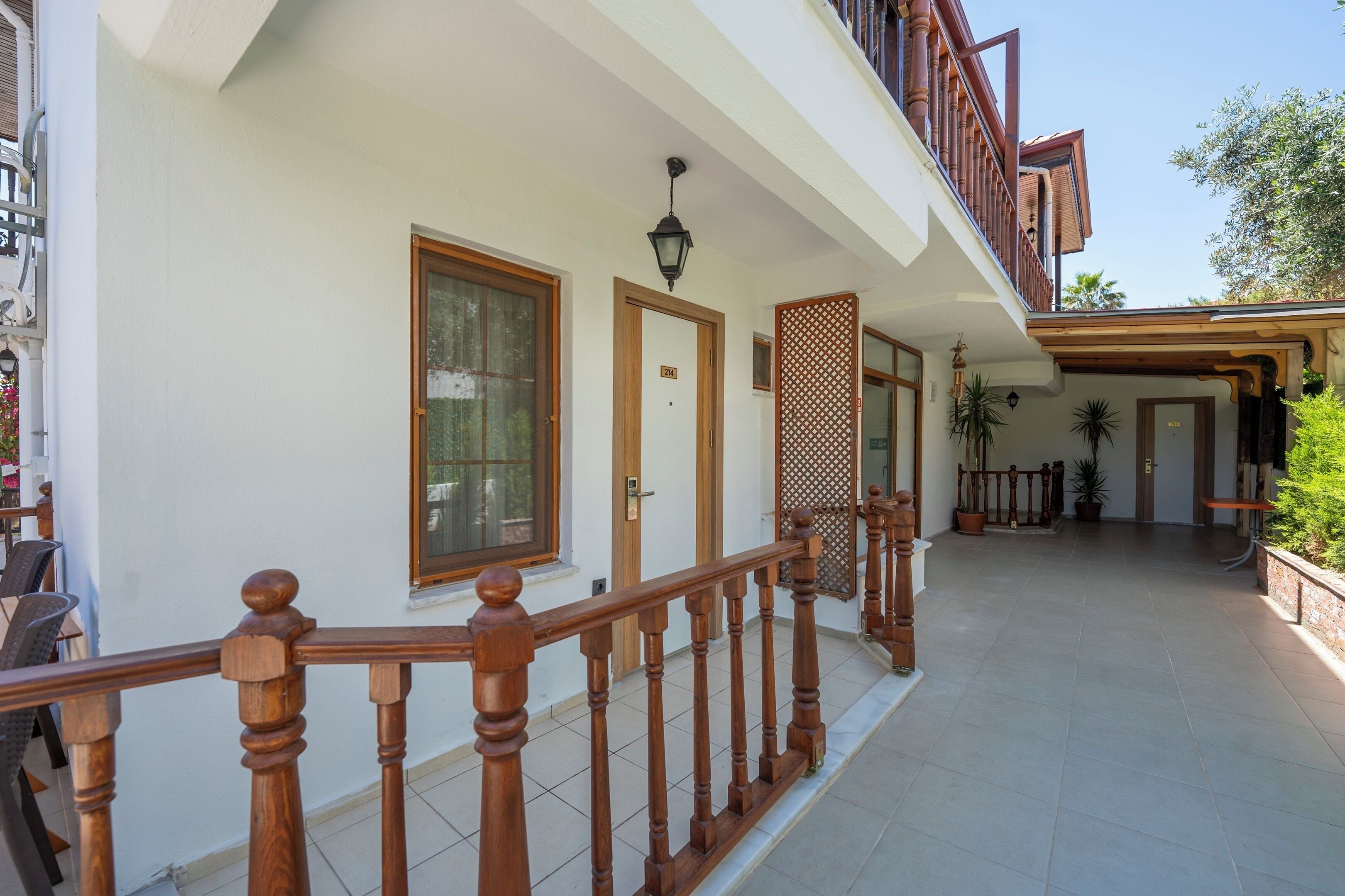 A building with a wooden balcony railing, a door, and a window.