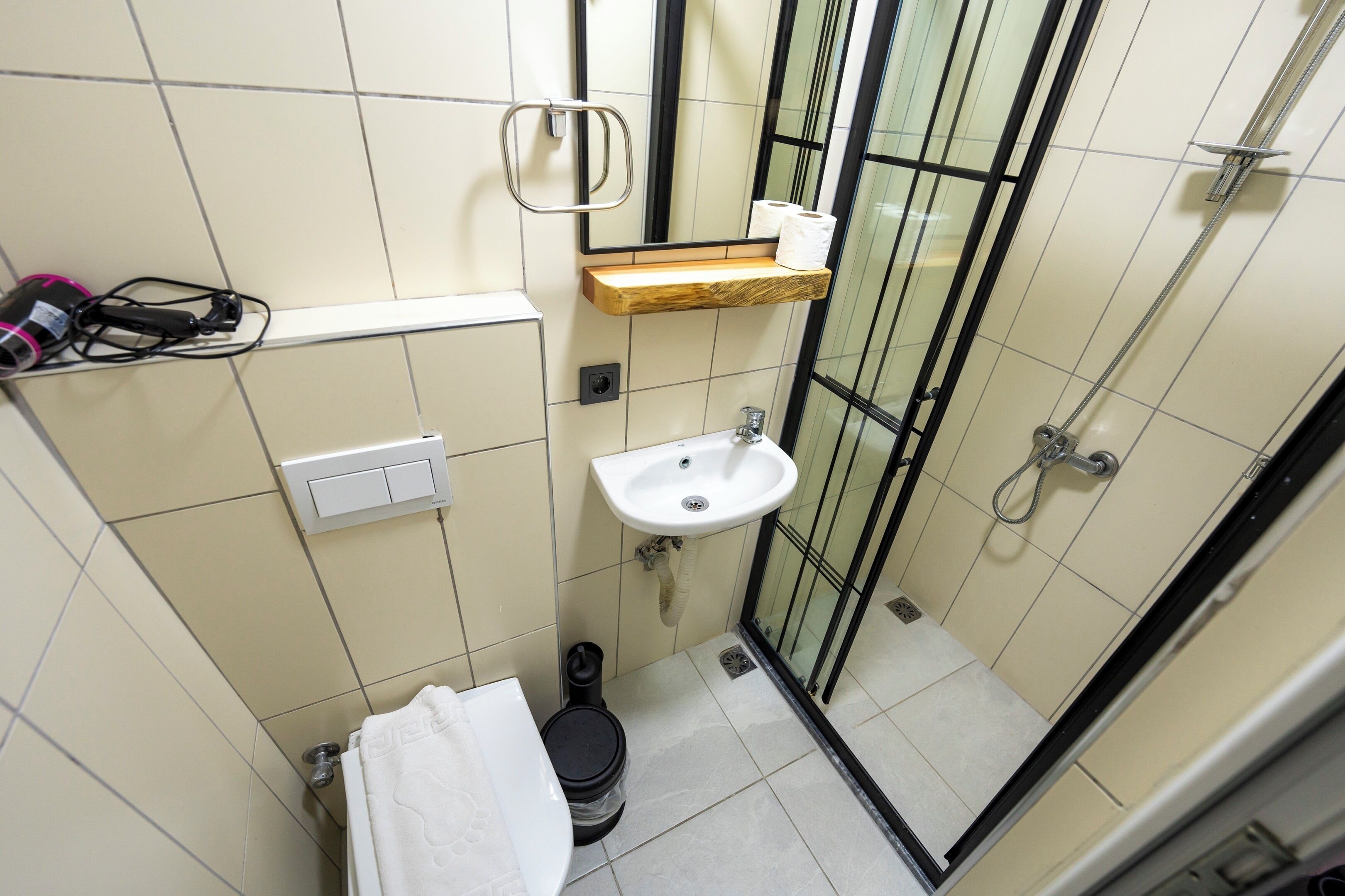 Un baño pequeño con inodoro, lavamanos y ducha.