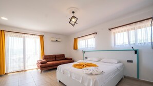 A hotel room with a bed, a sofa, and a window with curtains. - Ankakyaka Apart Hotel (Ula)