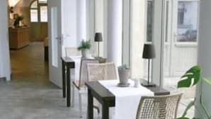 A dining area with a table and chairs, a potted plant, and a lamp. - DECKERT'S HOTEL AM KATHARINENSTIFT (Lutherstadt Eisleben)