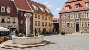 A cobblestone square with a central fountain, surrounded by historic buildings with red-tiled roofs. - DECKERT'S HOTEL AM KATHARINENSTIFT (Lutherstadt Eisleben)