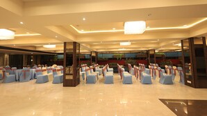 A spacious hall with rows of chairs, a polished floor, and modern lighting fixtures. - Hotel SN Blu (Ahmedabad)