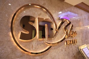 A hotel sign with a circular design and the name "Sky Hotel" in a modern font. - Hotel SN Blu (Ahmedabad)