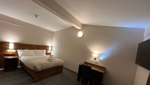 A hotel room with a bed, bedside tables, a desk, and a chair. - Burntisland House (Burntisland)