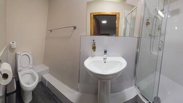A bathroom with a toilet, sink, and glass-enclosed shower.