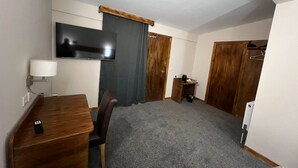 A compact room with a wooden desk, a chair, a television mounted on the wall, and a small table with a cup and saucer. - Burntisland House (Burntisland)