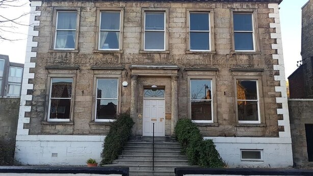 A two-story stone building with a symmetrical facade, large windows, and a central entrance with a door. - Burntisland House (Burntisland)