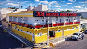 Un hotel con fachada amarilla y detalles en rojo, llamado "HB HOTEL BOULEVARD".
