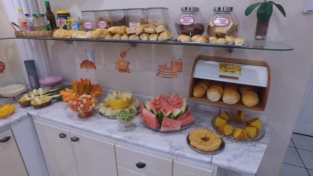 Un bufé con diversos alimentos, incluyendo pasteles, sándwiches y exhibiciones de fruta.