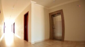 A hallway with a door and an elevator. - Dallas Palace Hotel (Rio Paranaiba)