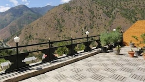 A terrace with a view of a mountainous landscape, a railing, and potted plants. - Dewa Thimphu by Realm (Thimphu)