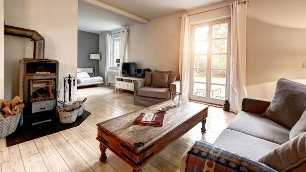 Una sala de estar acogedora con chimenea, sofá y una mesa de centro.
