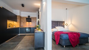 Un appartement moderne comprenant une cuisine, un coin repas et une chambre.