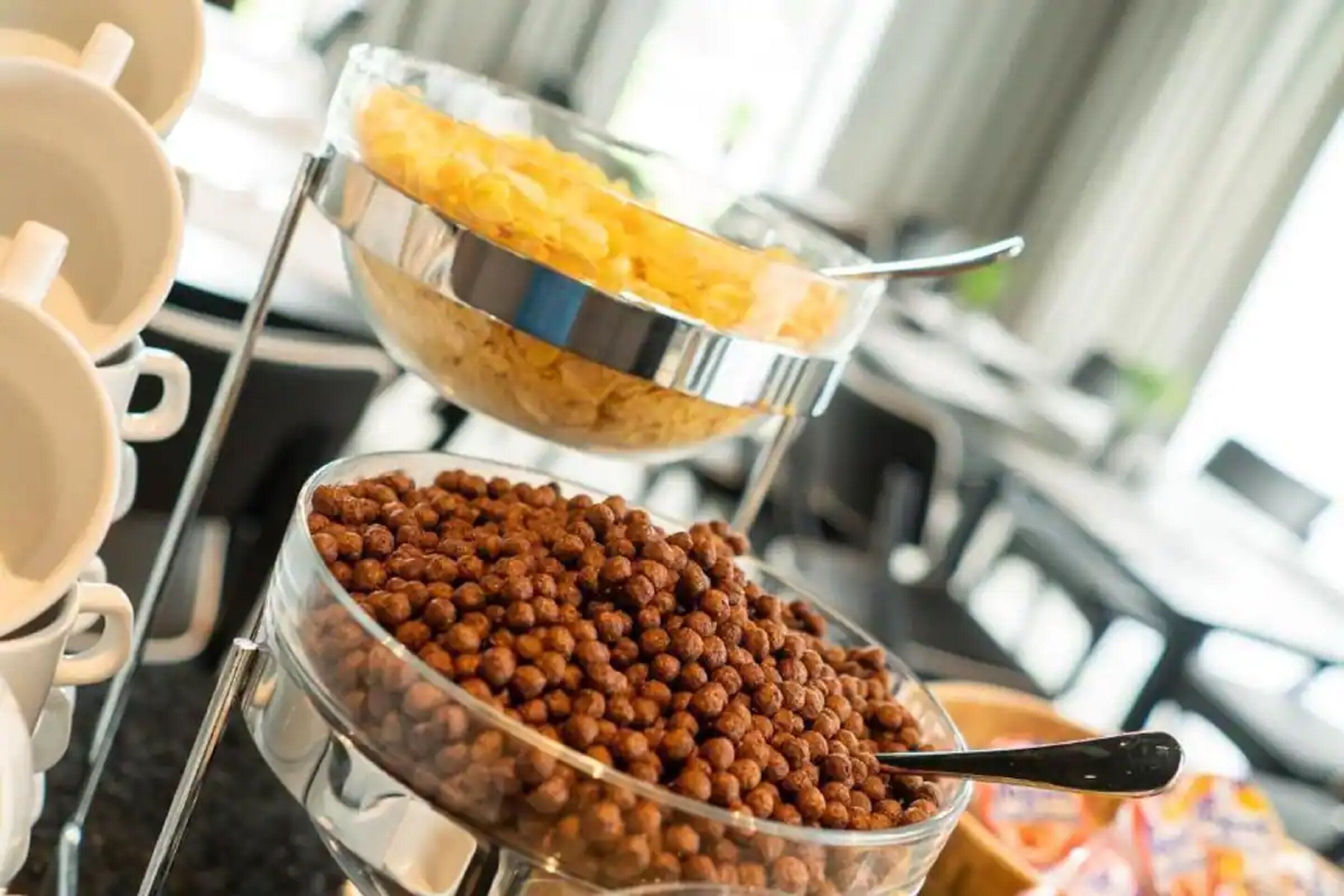 En buffet med skåle med cornflakes og nødder.