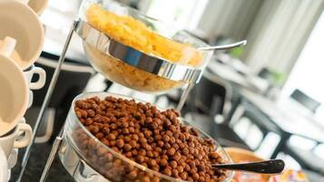 En buffet med skåle med cornflakes og nødder.
