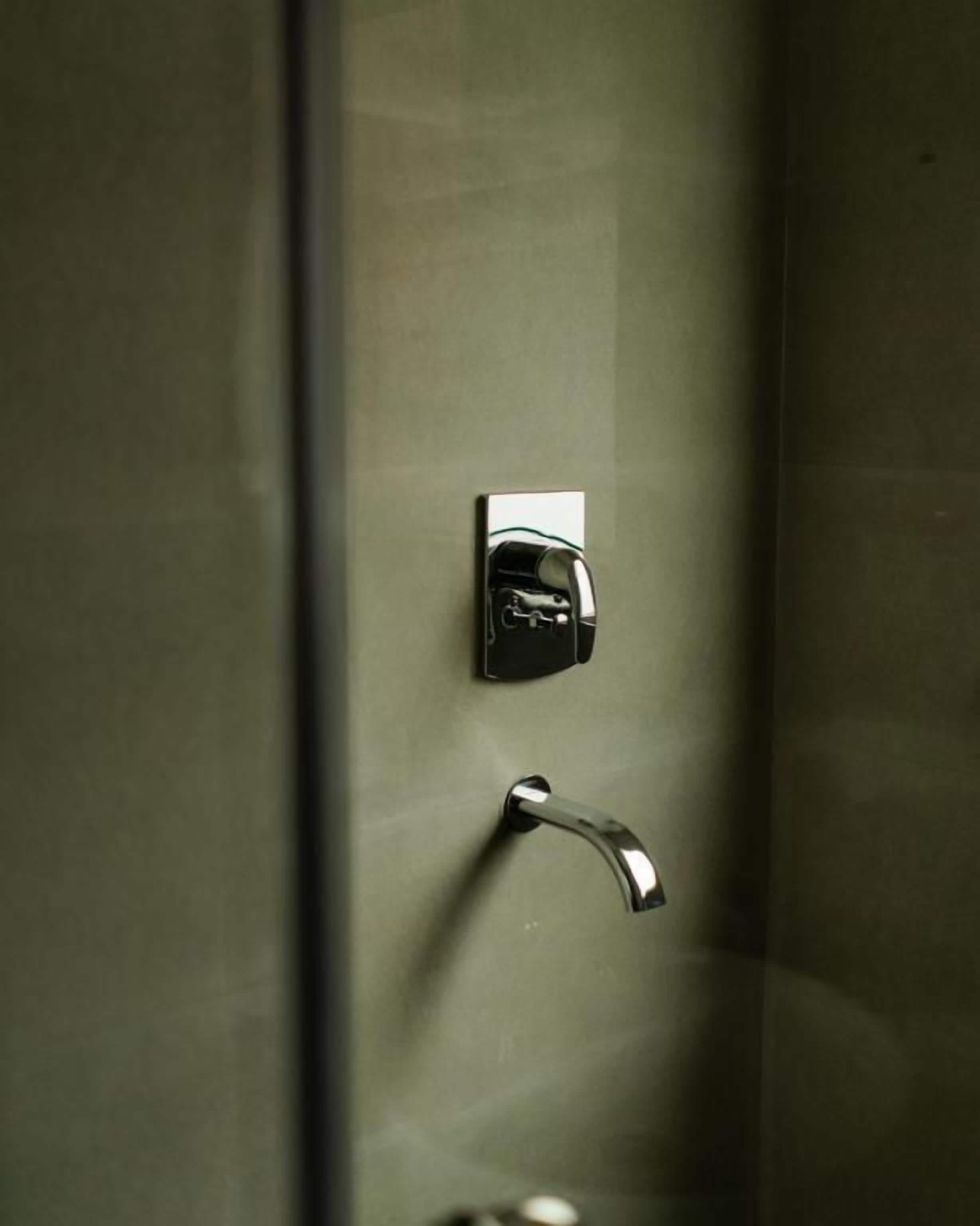 A metallic door handle and a keyhole on a wall.