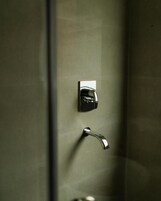 A metallic door handle and a keyhole on a wall.