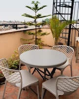 Una mesa redonda con cuatro sillas en una terraza en la azotea.