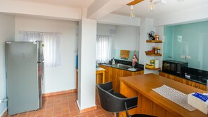 Una cocina compacta con refrigerador, encimera de madera y microondas.