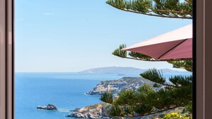 A coastal view with a clear sky, rocky terrain, and a body of water. - FnK Apartments (Malevizi)